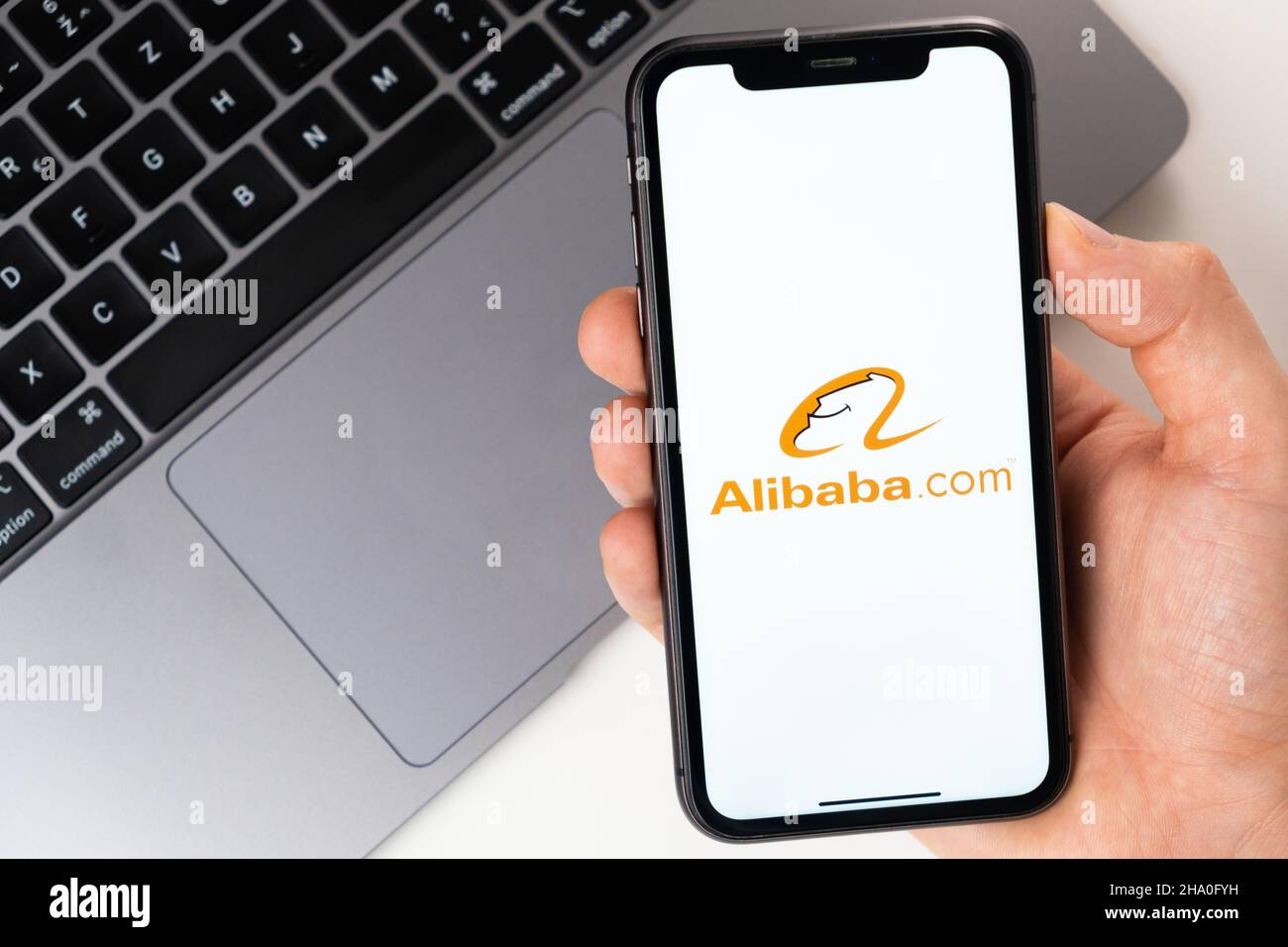 Alibaba mobile application on the smartphone screen. Make purchases while sitting at home using a mobile app or laptop. A smartphone in a man hand. November 2021, San Francisco, USA Stock Photo