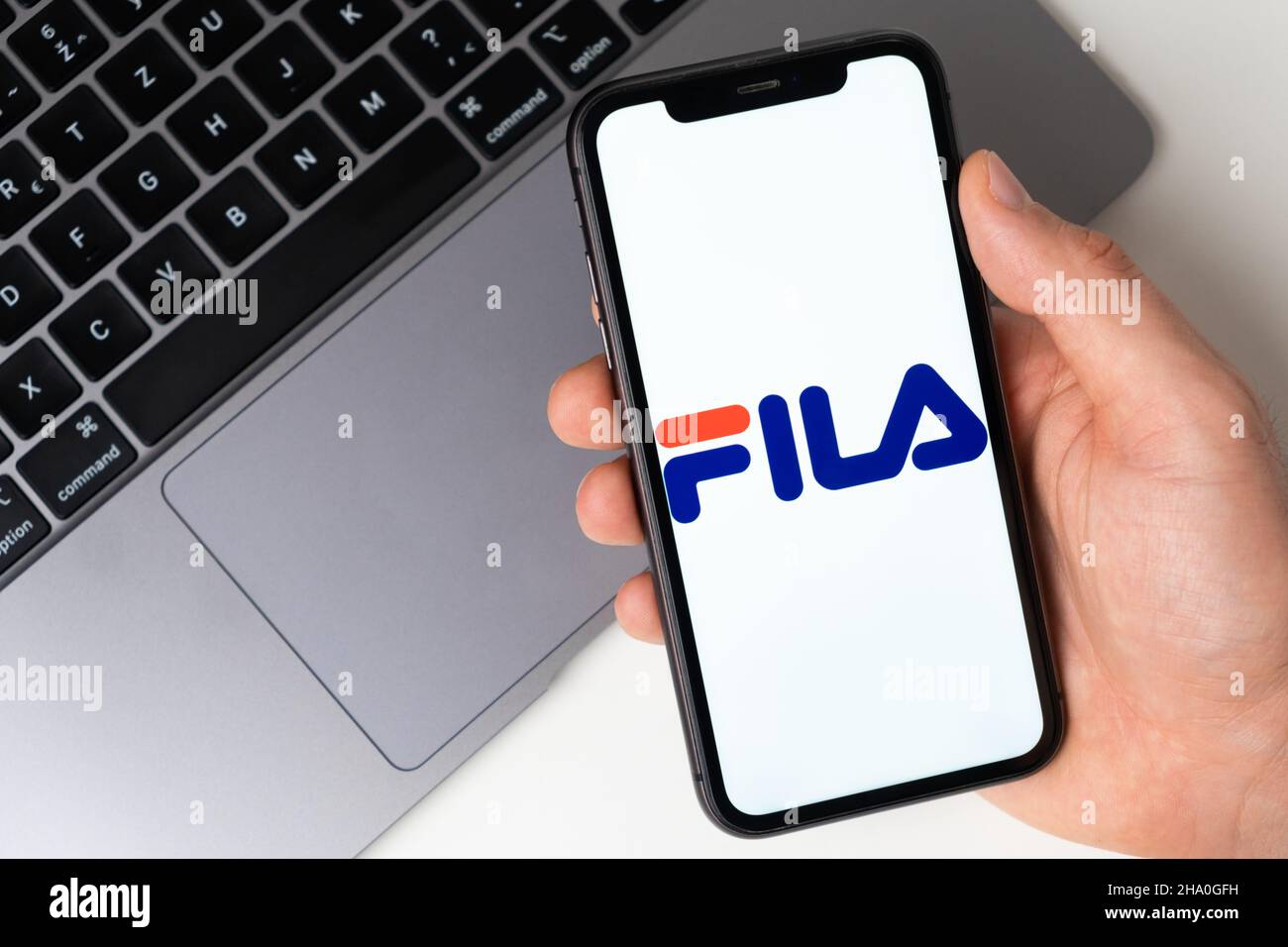 Fila app logo on the iPhone screen for online shopping with a laptop on the  background. November 2021, San Francisco, USA Stock Photo - Alamy