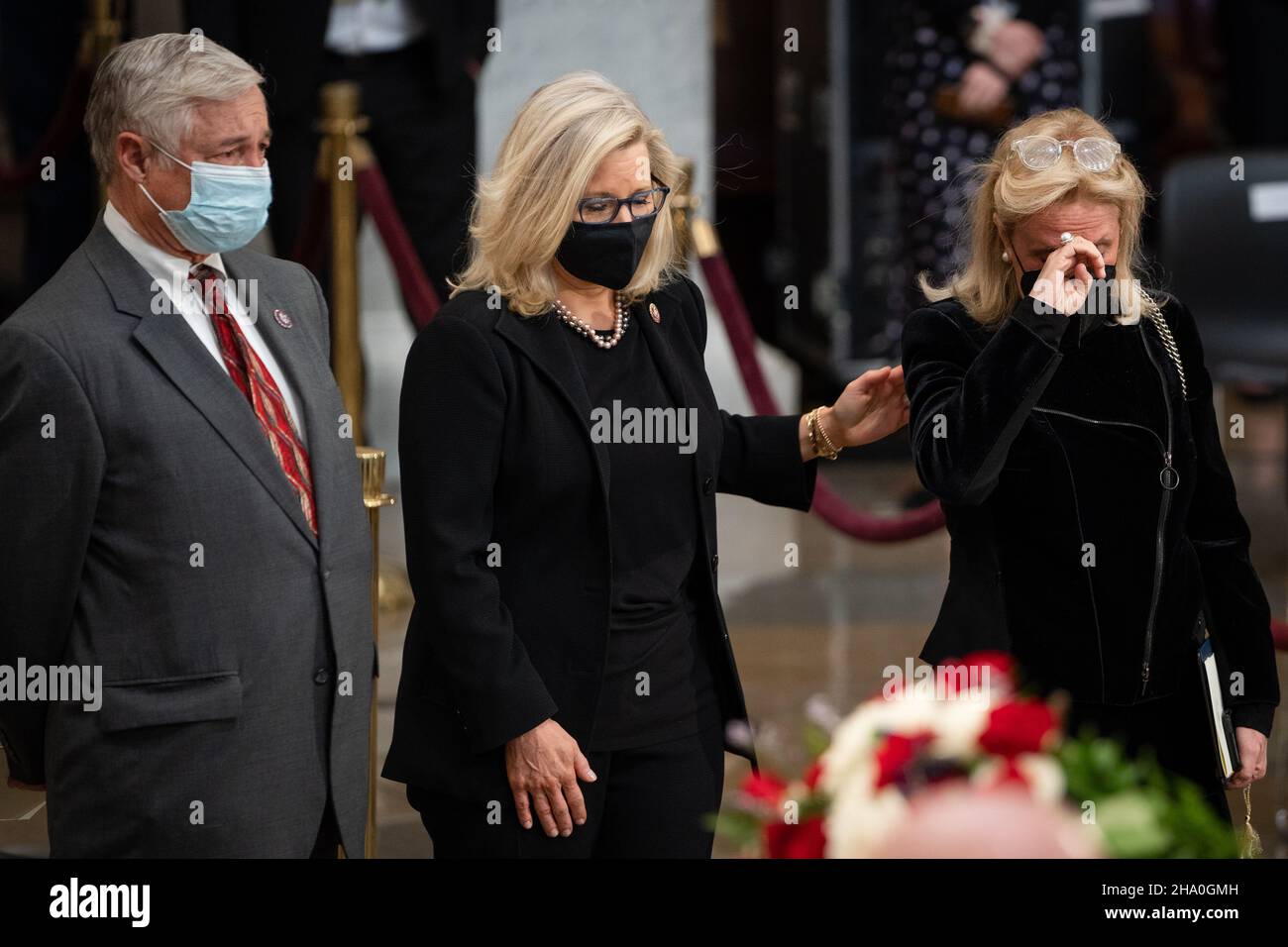 United States Representative Liz Cheney (Republican of Wyoming), center, and US Representative Debbie Dingell (Democrat of Michigan), right, become emotional while paying their respects to former Senator Robert J. Dole (R-KS) as he lies in state at the Rotunda of the U.S. Capitol in Washington, DC on Thursday, December 9, 2021. Credit: Sarahbeth Maney/Pool via CNP /MediaPunch Stock Photo