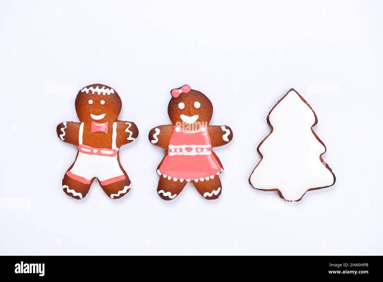 The hand-made eatable gingerbread little men and New Year Tree on white background Stock Photo