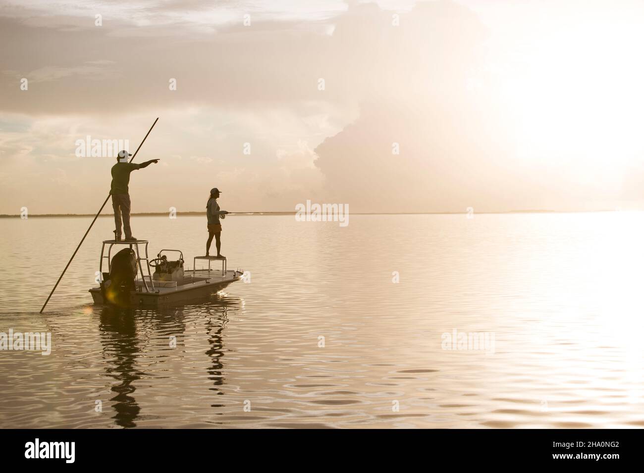 A man and woman fly fishing on a flats boat in the Florida Keys Stock