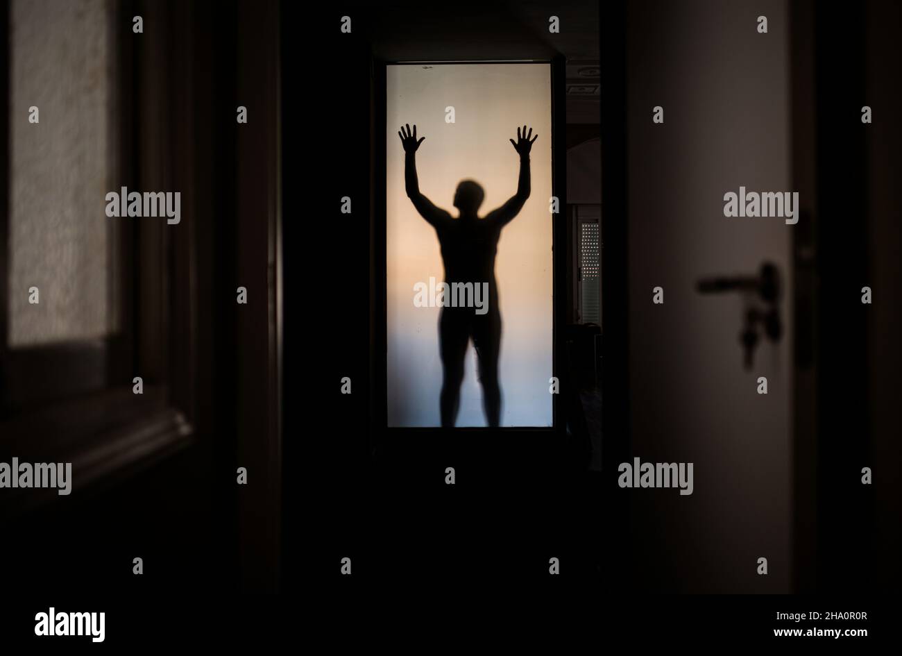 shadow of man behind glass Stock Photo
