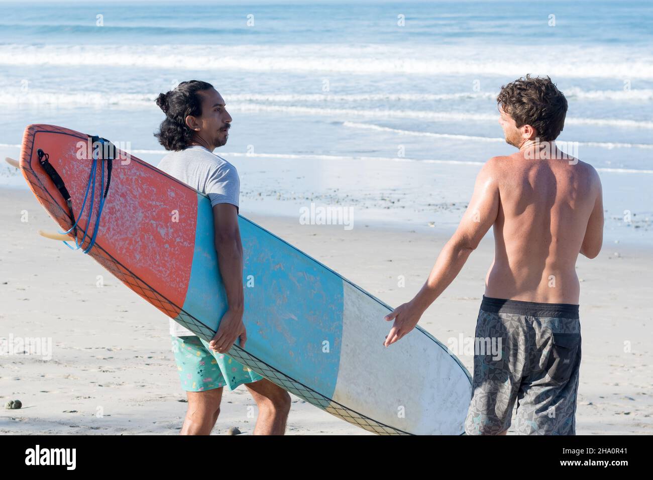 Rear view of men talking at beach Stock Photo - Alamy