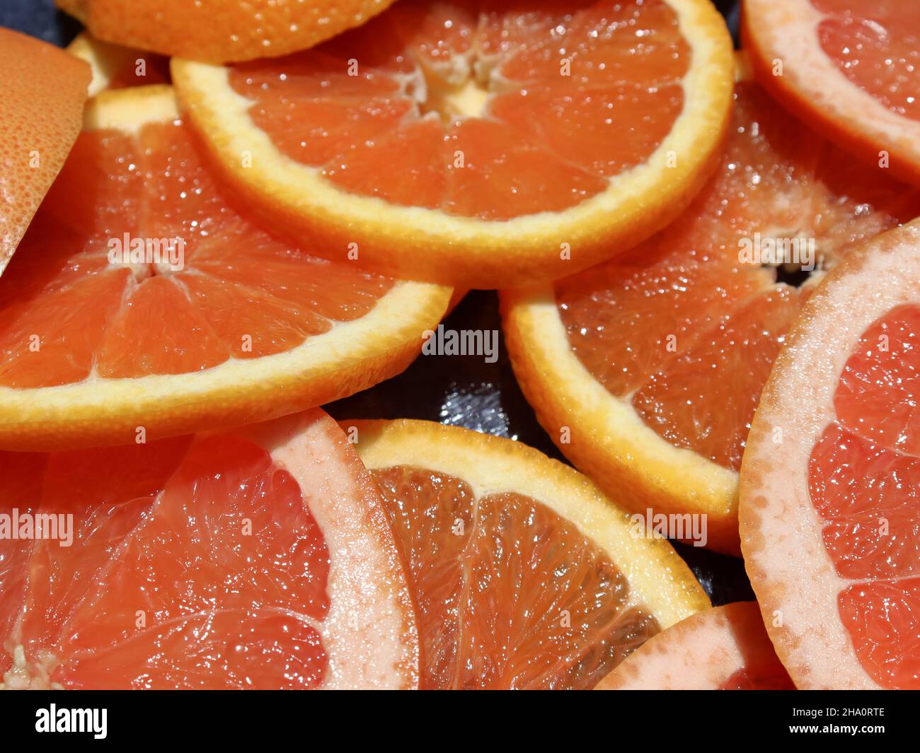 Sliced orange and grapefruit on a kitchen board Stock Photo