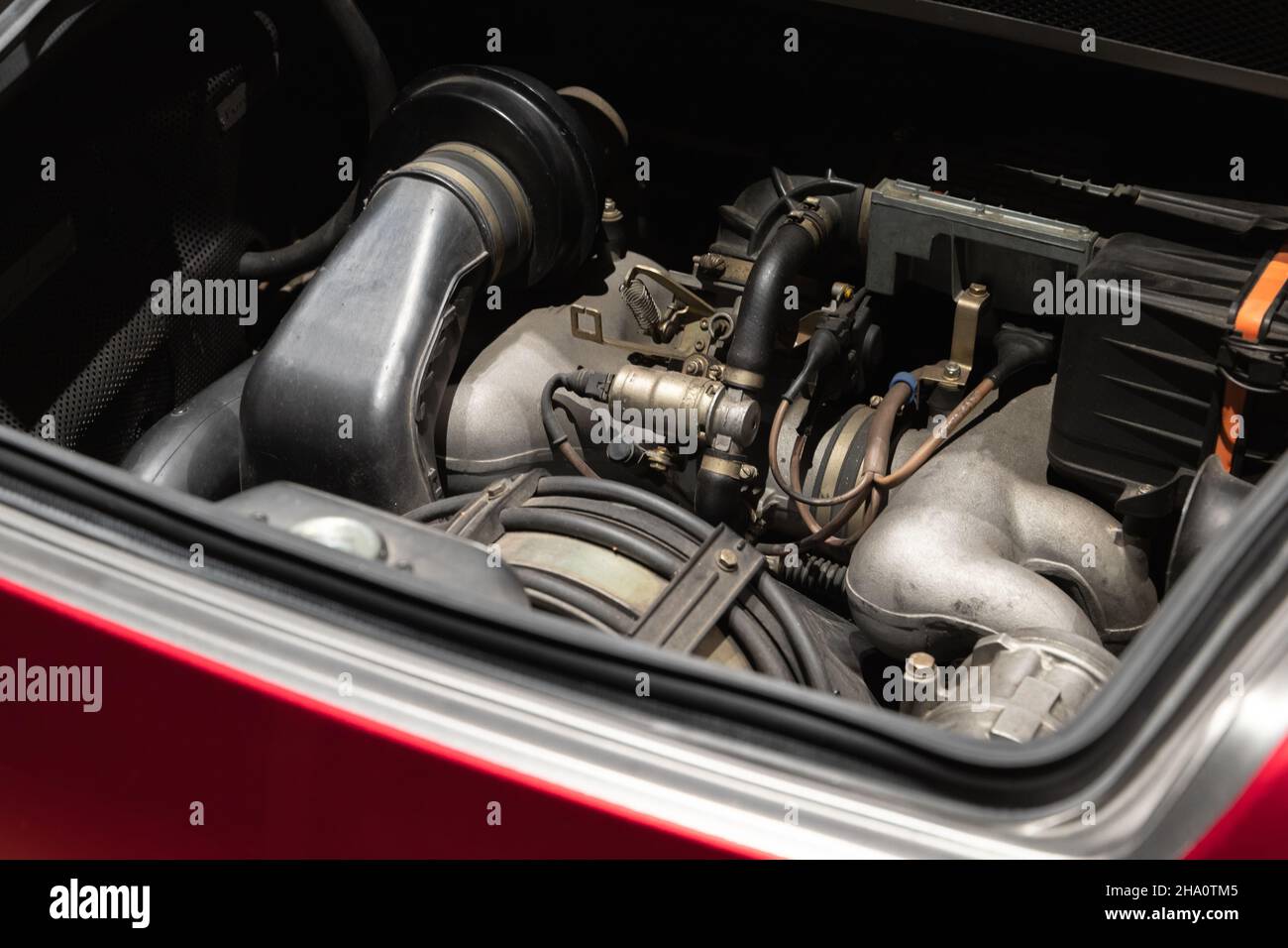 Sports car engine is under open hood, red roadster turbo motor Stock Photo