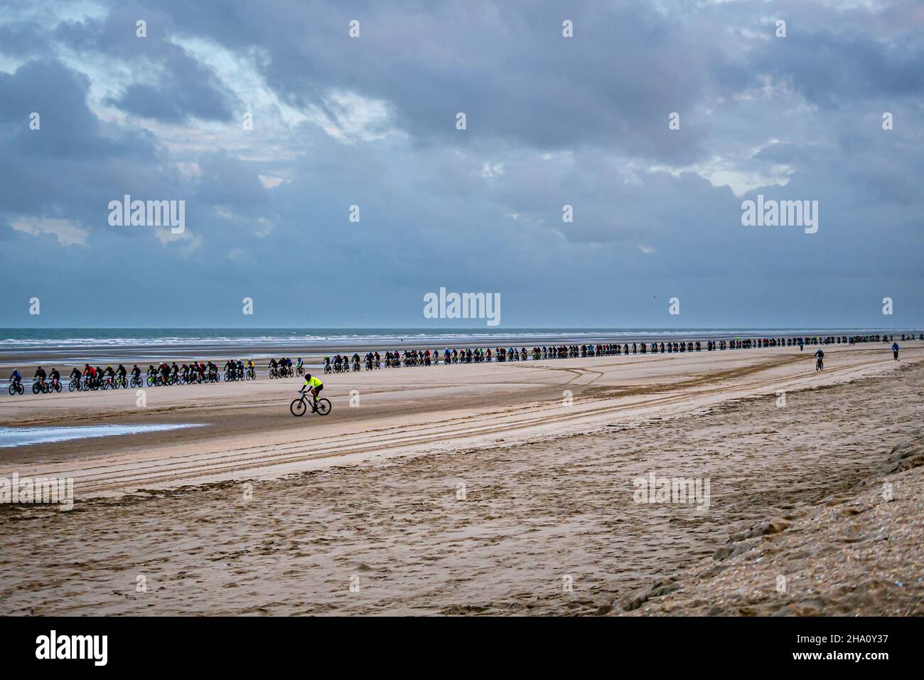 Long line of racers during Bike Race 'Beach Endurance' at the beach of De Panne, Belgium, and Bray-Dunes, France Stock Photo