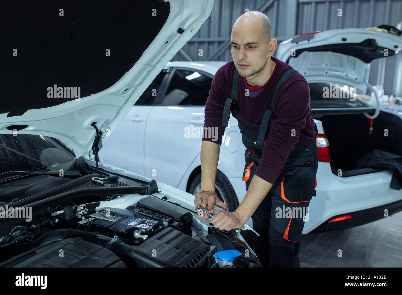 A male automech is inspecting the car's engine. Car service and car ...