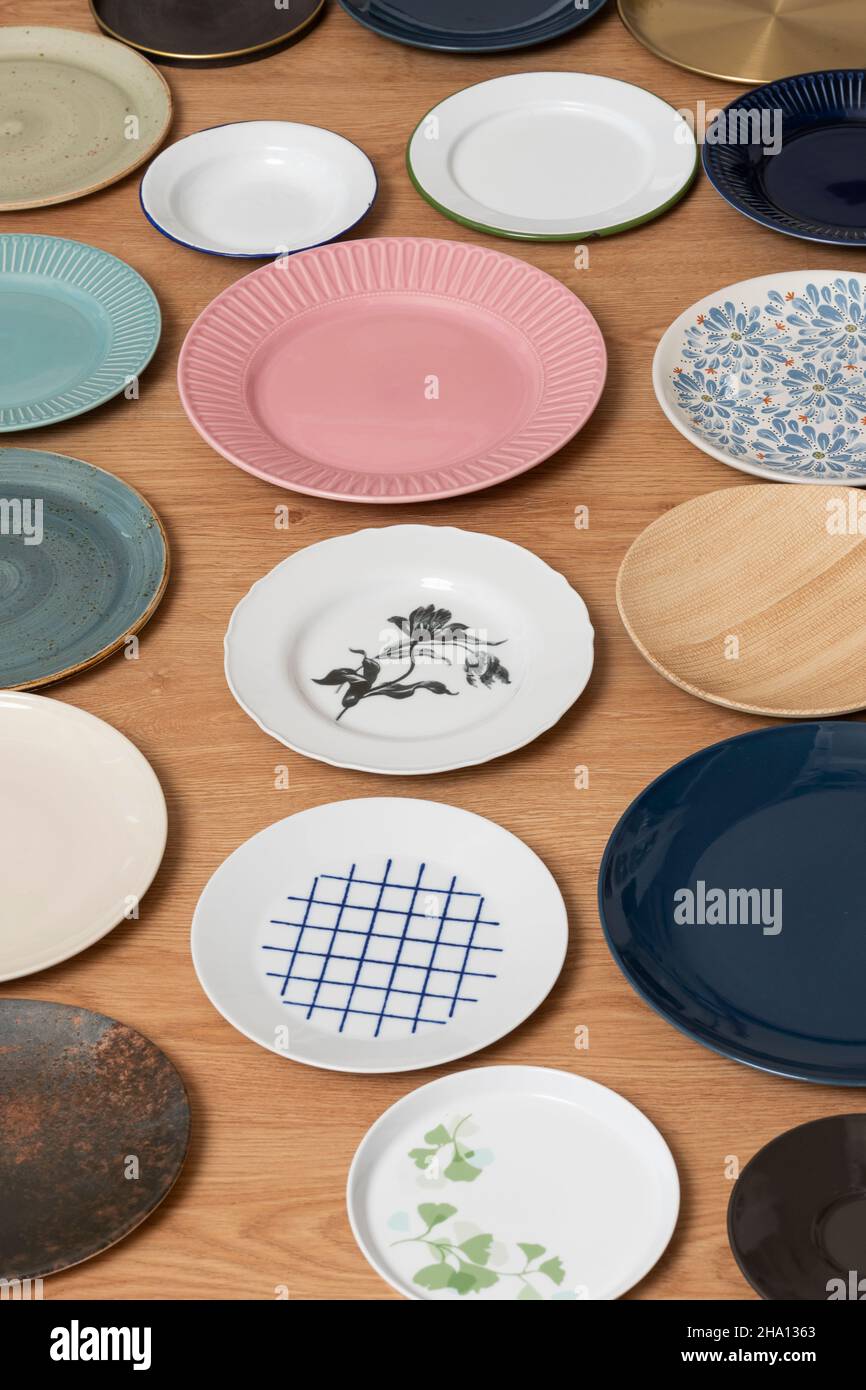 Set of plates of different materials, styles and colors on oak wood