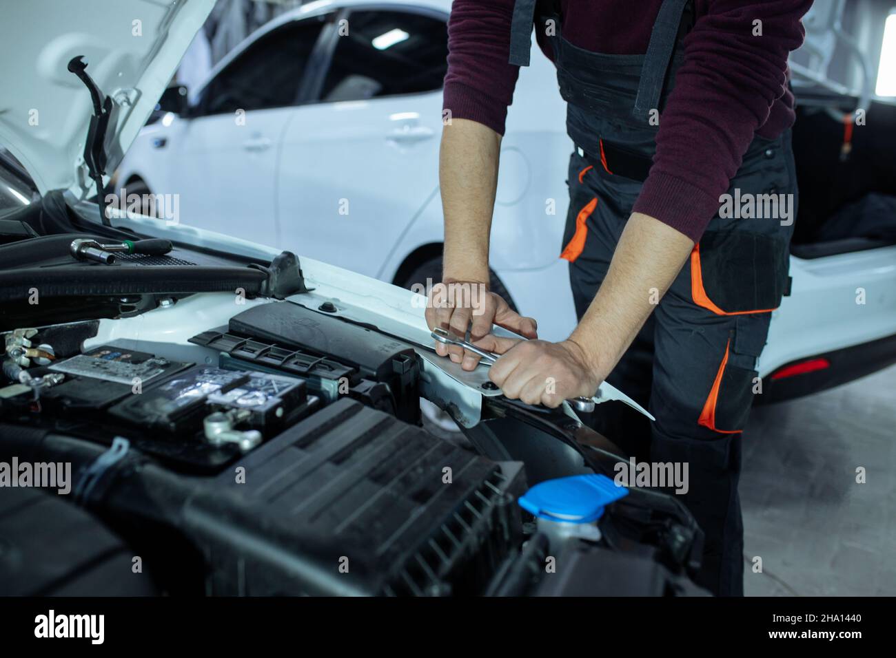 A male automech is inspecting the car's engine. Car service and car ...