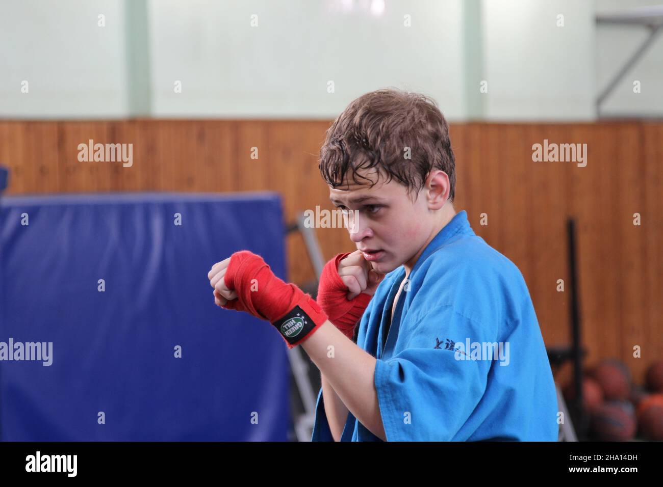 Martial arts. Japan. Portrait of a young man, in a blue sports kimono in the gym, performs exercises in training. Stock Photo