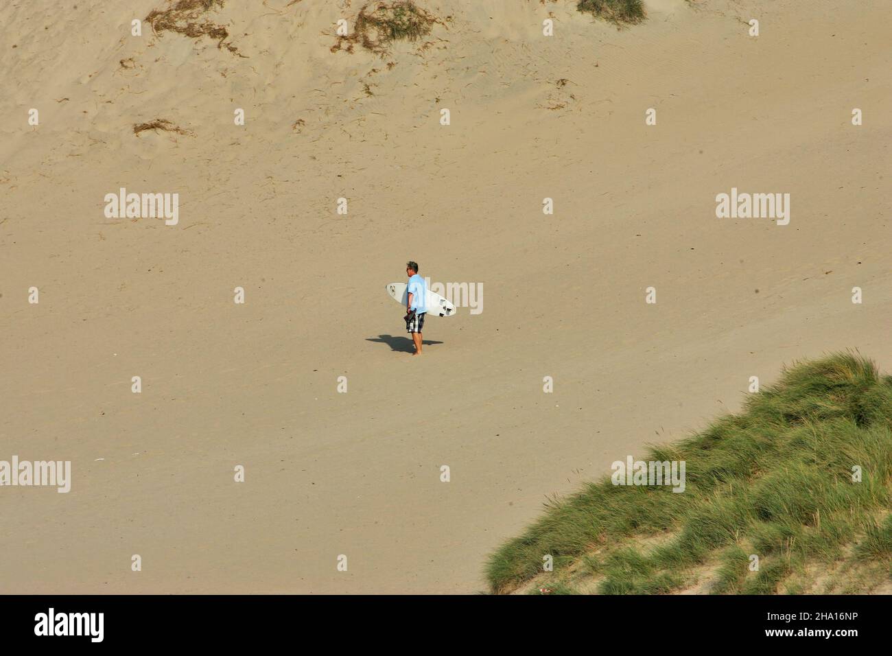 Aerial view of a surfer walking with his board on the beach Stock Photo ...
