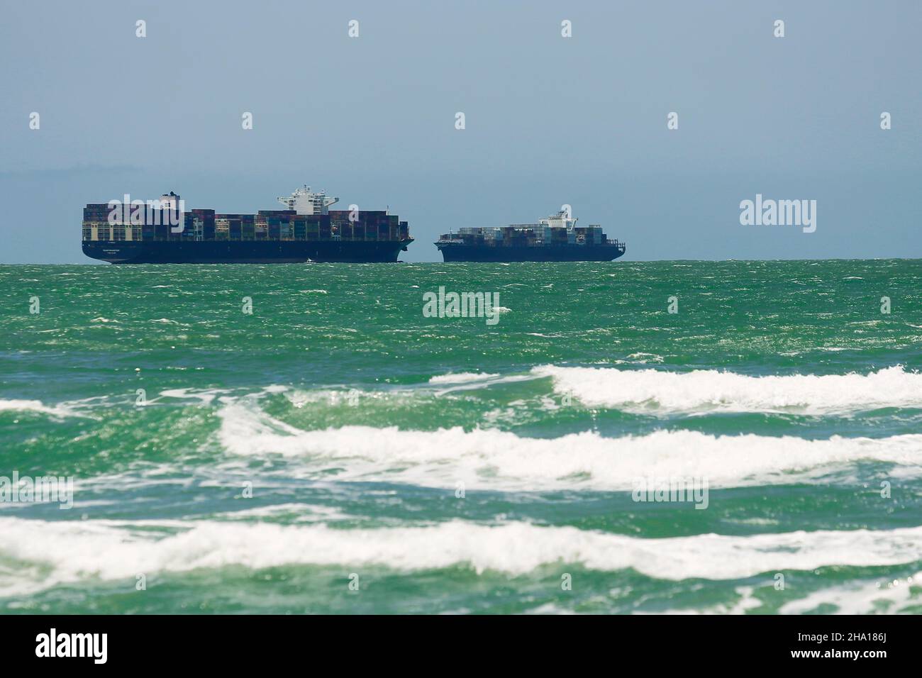 Cargo ship of shipping company at sea. Container vessel shipping operator. Commercial goods water transportation. Stock Photo