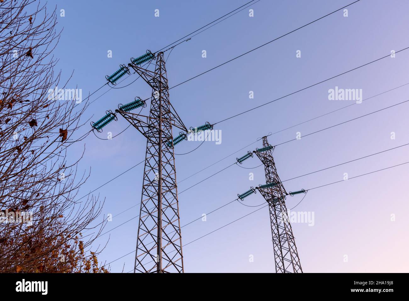 Two electricity pylons against clear sky at sunset Stock Photo - Alamy