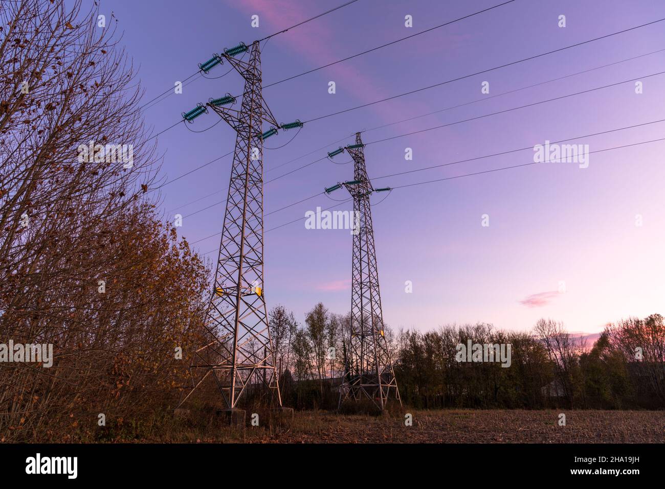 View of wo electricity pylons in a field under a clear winter sky at ...