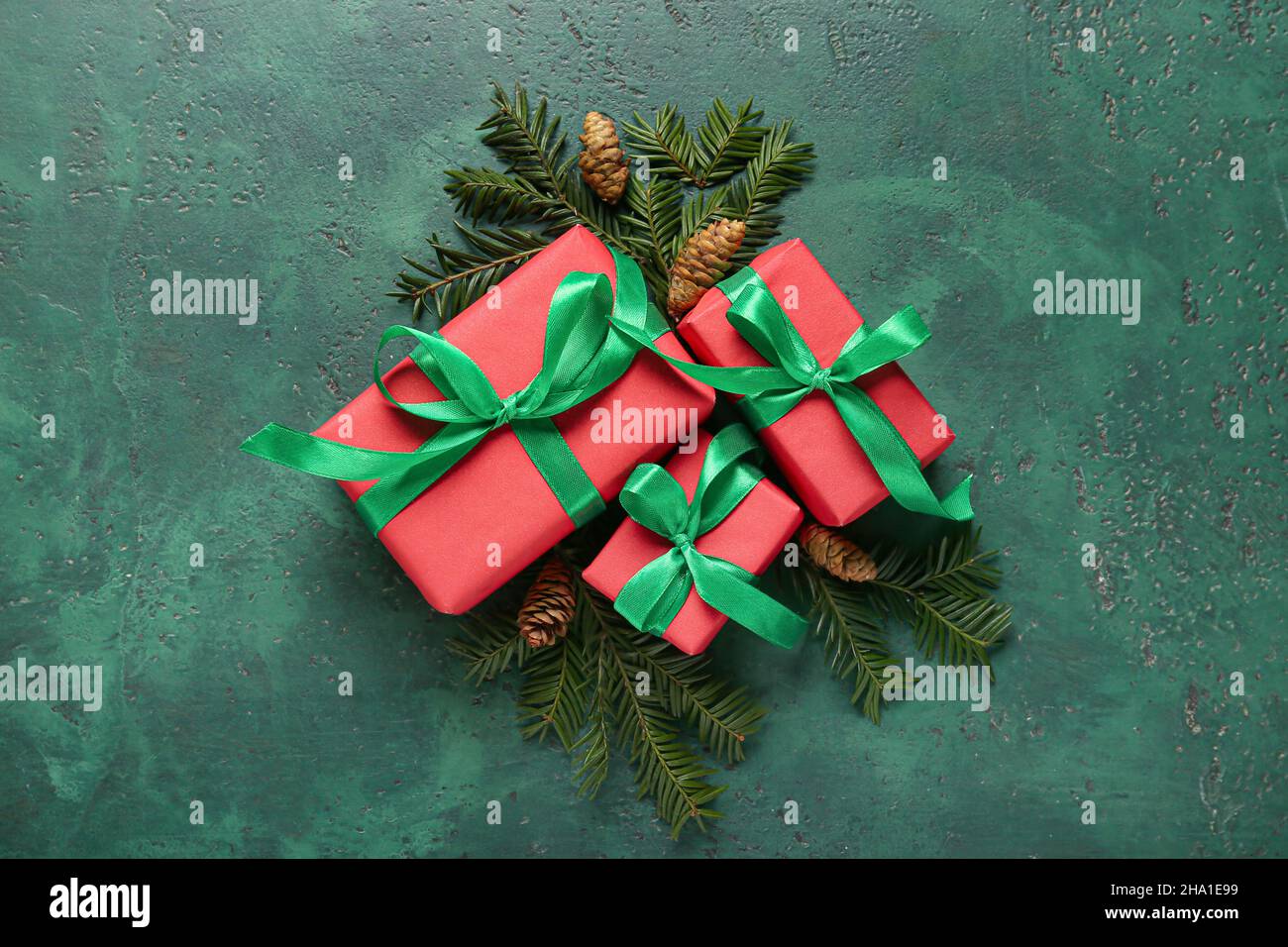 Christmas gift boxes, fir branches and cones on color background Stock ...