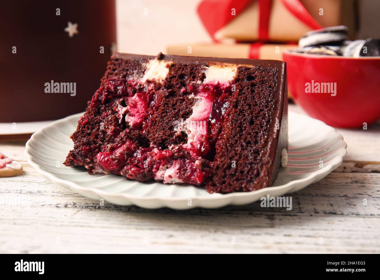 Plate with piece of tasty Christmas chocolate cake on light wooden ...