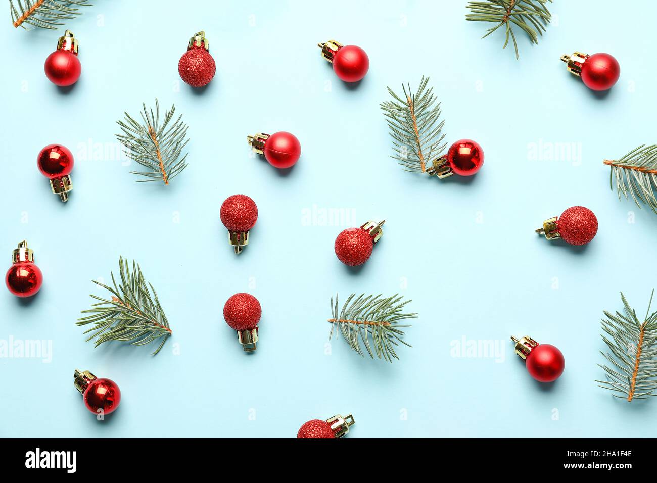 Red Christmas balls and fir branches on blue background Stock Photo - Alamy