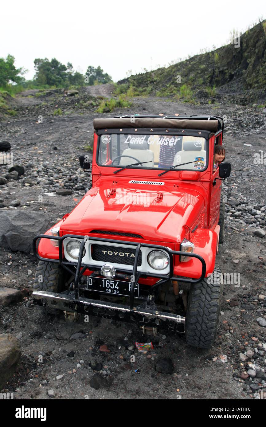 A red Toyota 4x4 jeep with children as passengers on the flanks of Mout ...