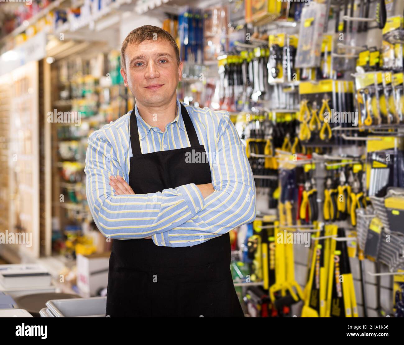 Man seller in apron having tools in hands Stock Photo