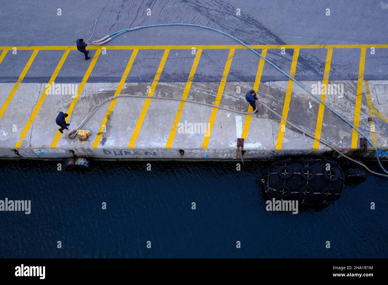 Crew pulling in the ropes preparing to dock a cruise ship Stock Photo
