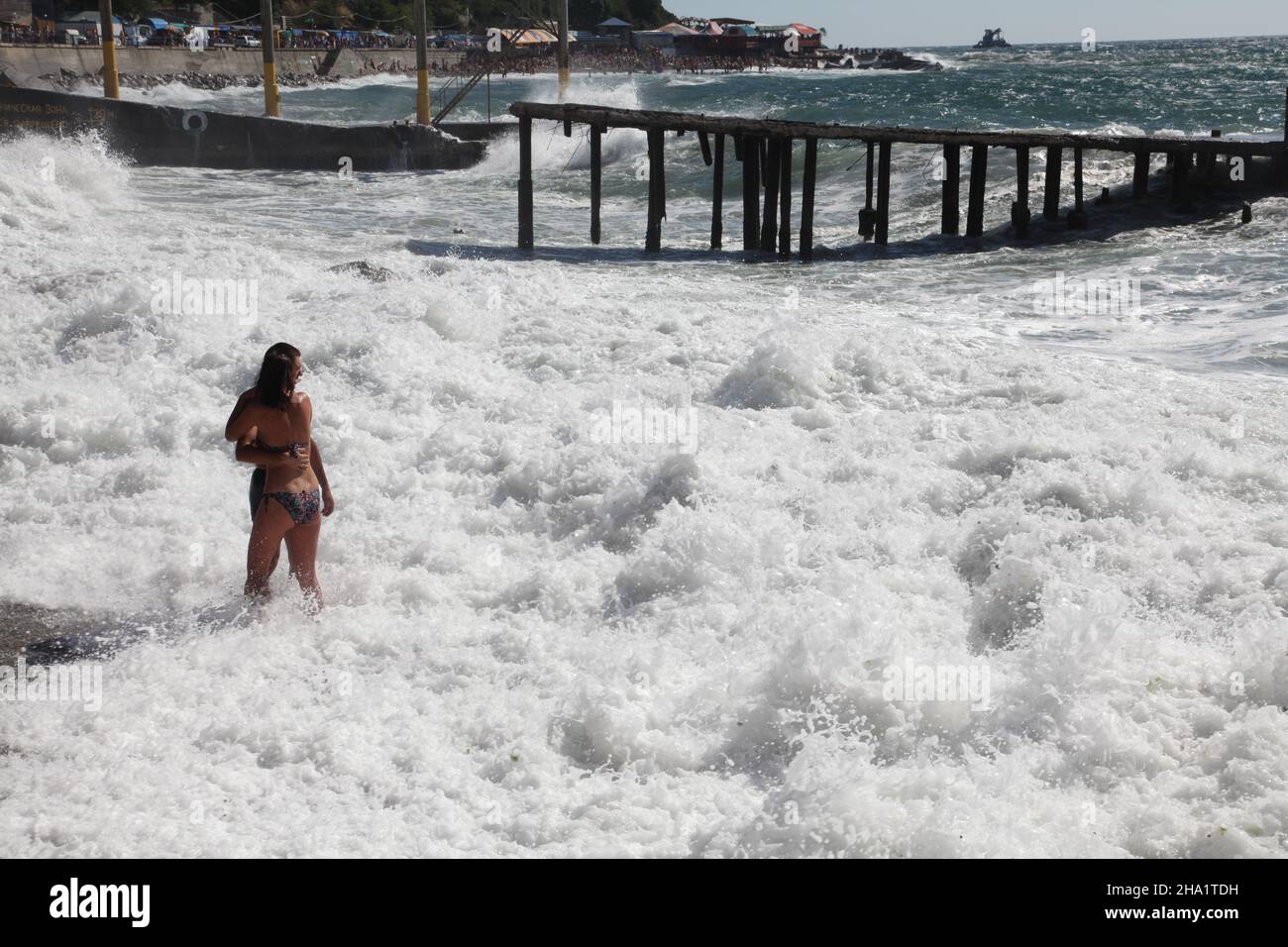 Young Ukrainian couple enjoys 2011 vacation on Black Sea shore during a storm in Simeiz, Crimea, near old peer in the sea of foam and refreshing wind. Stock Photo
