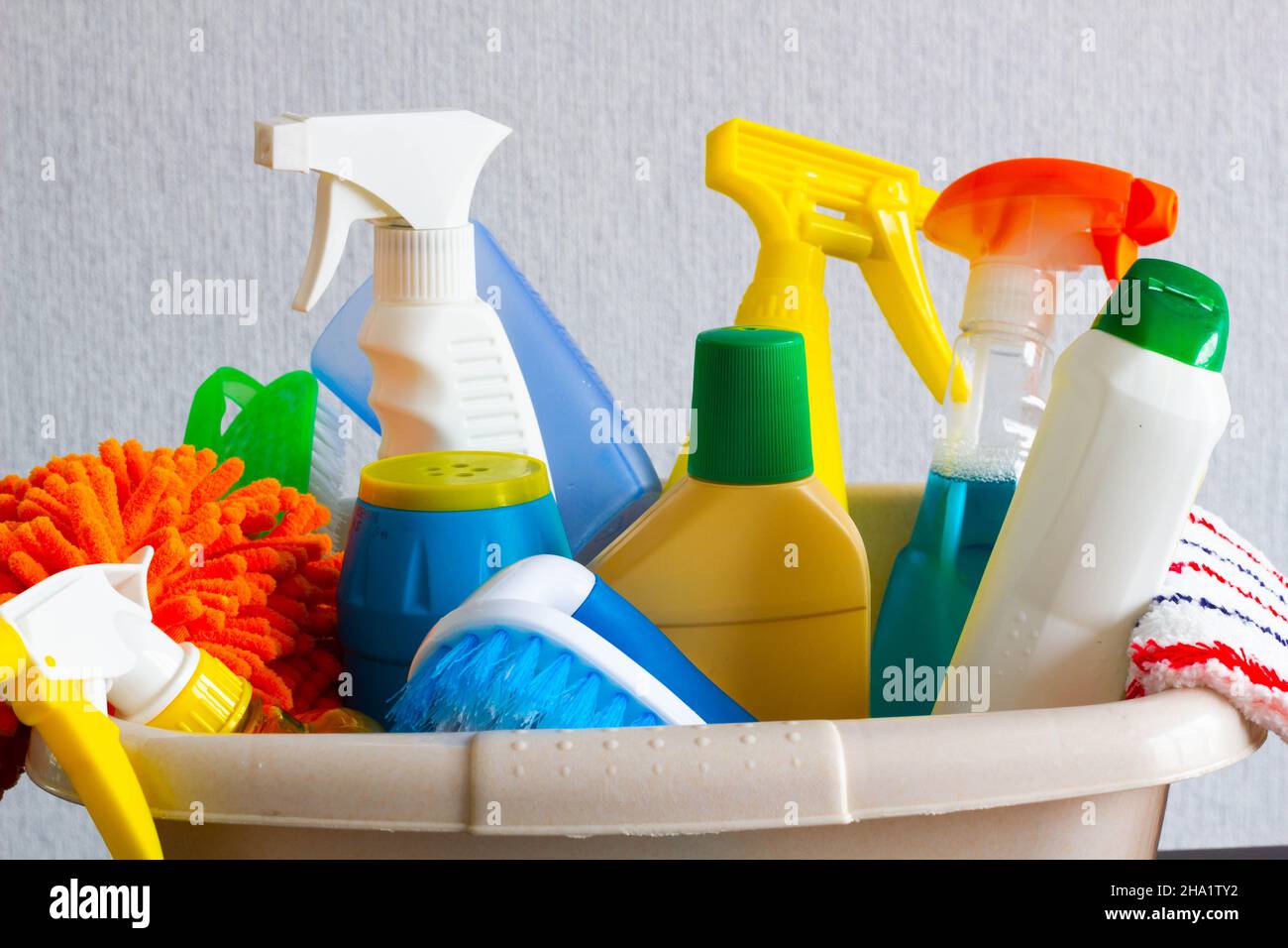 Basket with detergents on the table. Harmless dishwashing detergent. Detergent for washing floors. Household cleaning chemicals. Chemical substances. Stock Photo