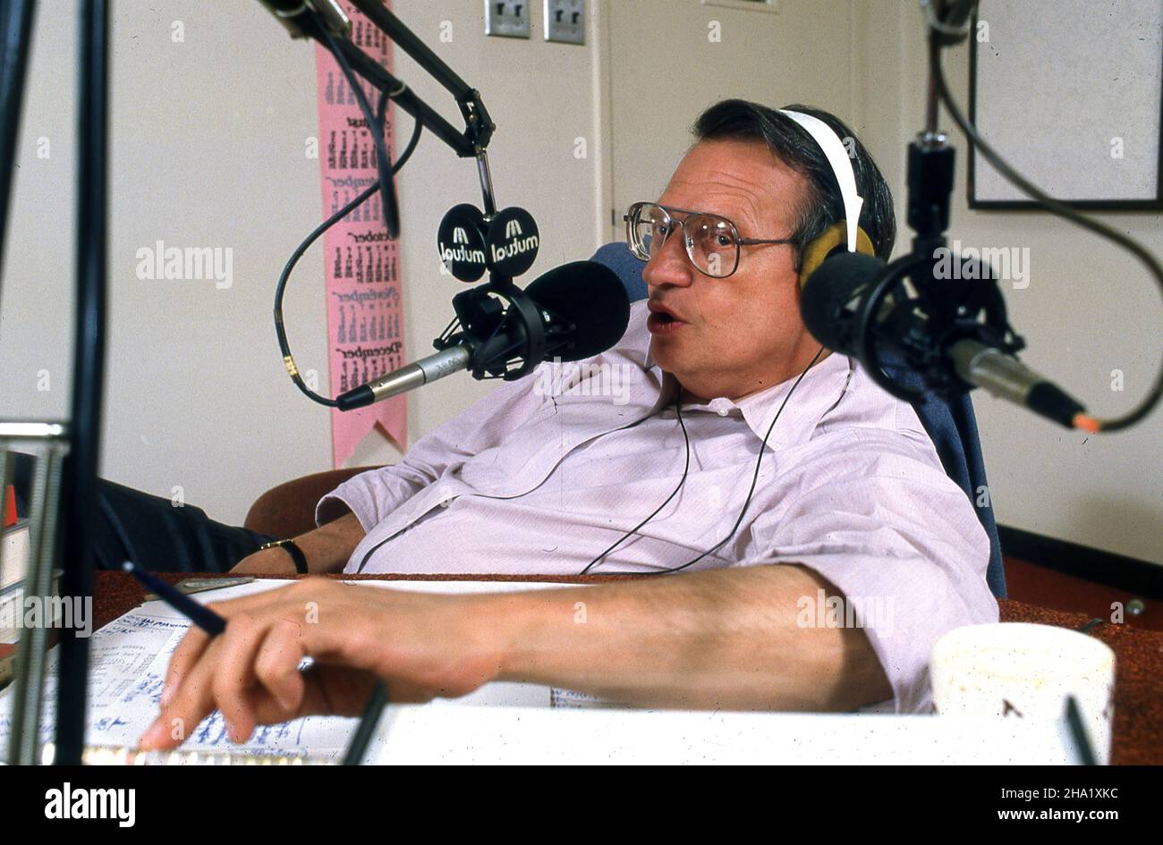 Long before CNN Larry King had a popular radio program that started late and went for the better part of the night.. TIME magazine..  I remember that I had worked all day  during that day. I  photographed the first part of the radio show staying out of the way and staying quiet.  King had no guests and it was just him sitting talking into his microphones. I was determined to stay until the end of the program just in case a picture would occur.  So far nothing and I kinda went to sleep.  King looked over, brought a microphone over, woke me, and began to interview the TIME magazine photographer. Stock Photo
