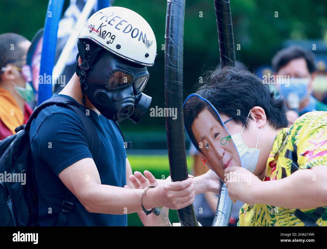 Taipei, Taipei, Taiwan. 10th Dec, 2021. A demonstrator wearing a mask with the face of Chinese president Xi Jinping handcuffs another protester with respirator, during a protest boycotting the Beijing Winter Games 2022, outside the Bank of China (Taipei Branch), following several diplomatic boycotts of the Games. The United States, Canada, UK, and Australia have pledged not to send officials to attend the Games as a mean to boycott the China, following the disappearance of Chinese tennis player Peng Shuai and human rights crackdowns on Hong Kong and Xinjiang. (Credit Image: © Daniel Ceng Sh Stock Photo