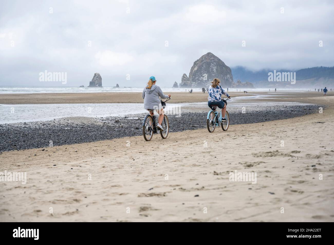 Two middle-aged women amateur cyclists rides bicycles traveling on the cost line along the Northwest Pacific Ocean preferring an active healthy lifest Stock Photo