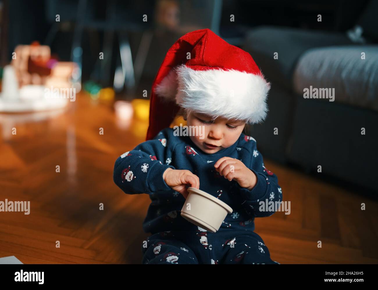 Cute little boy in Christmas costume siting on a floor and playing Stock Photo