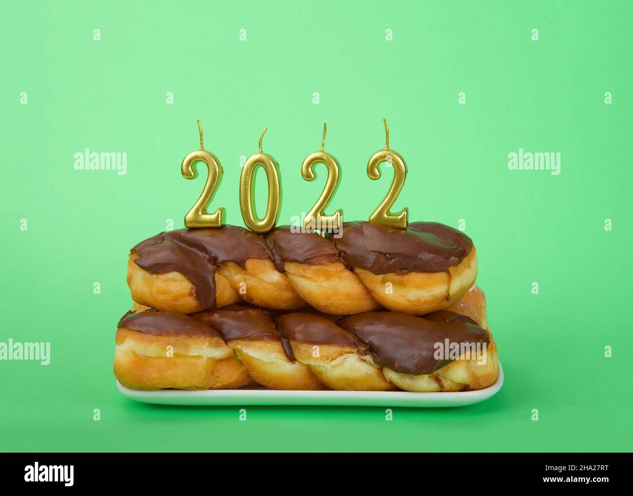 Chocolate frosted glazed twist donuts stacked on a rectangular plate
