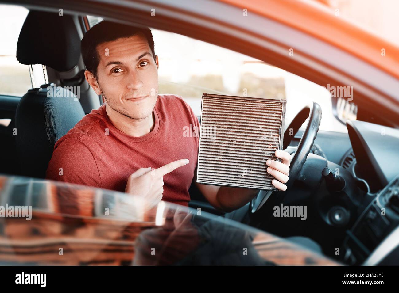 Man changes old polluted filter for the ventilation of the car interior