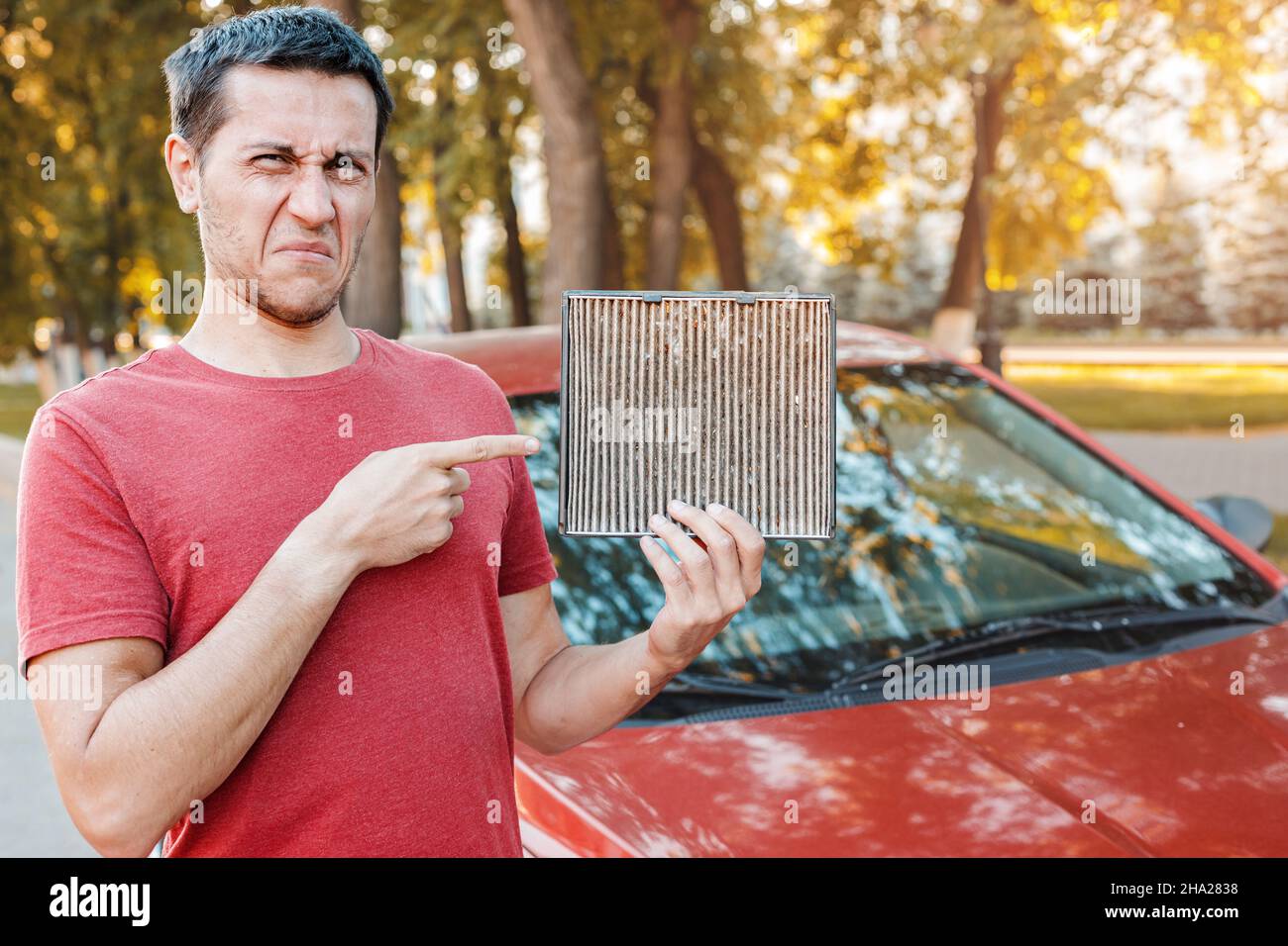 Frustrated car driver with an allergy to dust collected in an old dirty