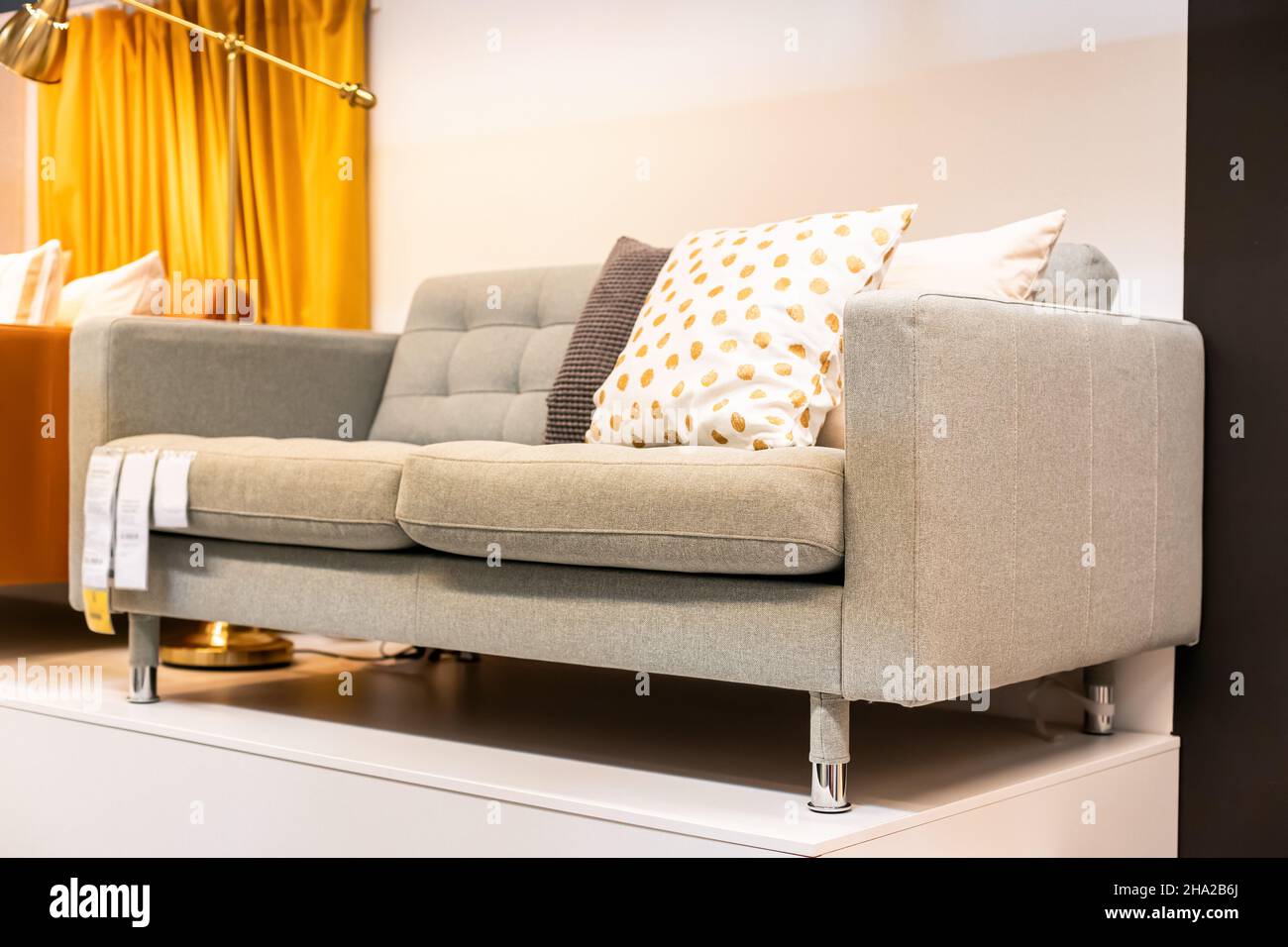Stylish and inexpensive gray sofa in the showroom of a furniture store