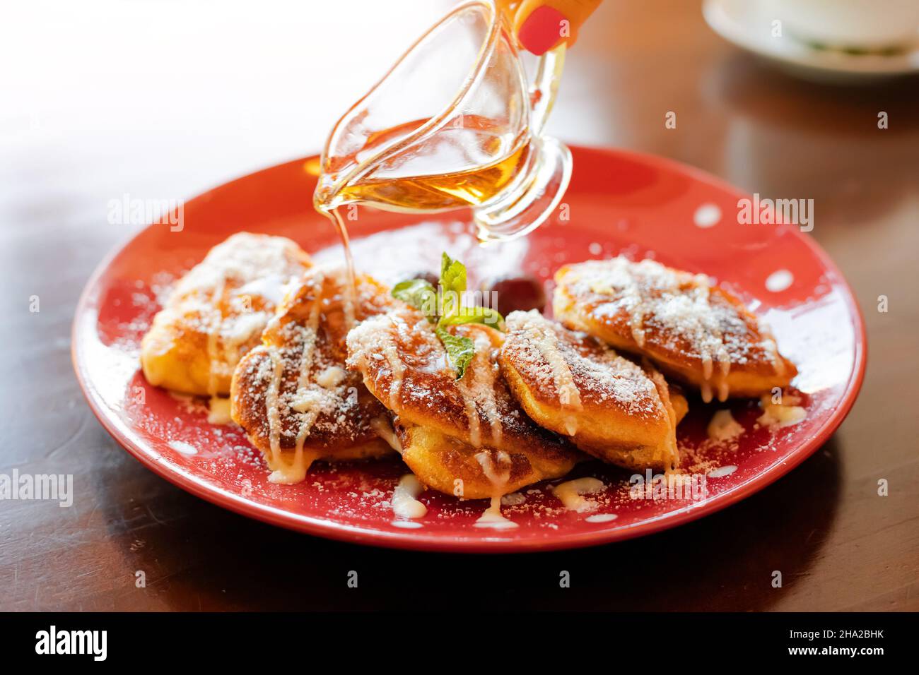 maple syrup is poured on sweet pancakes. Delicious dessert with an