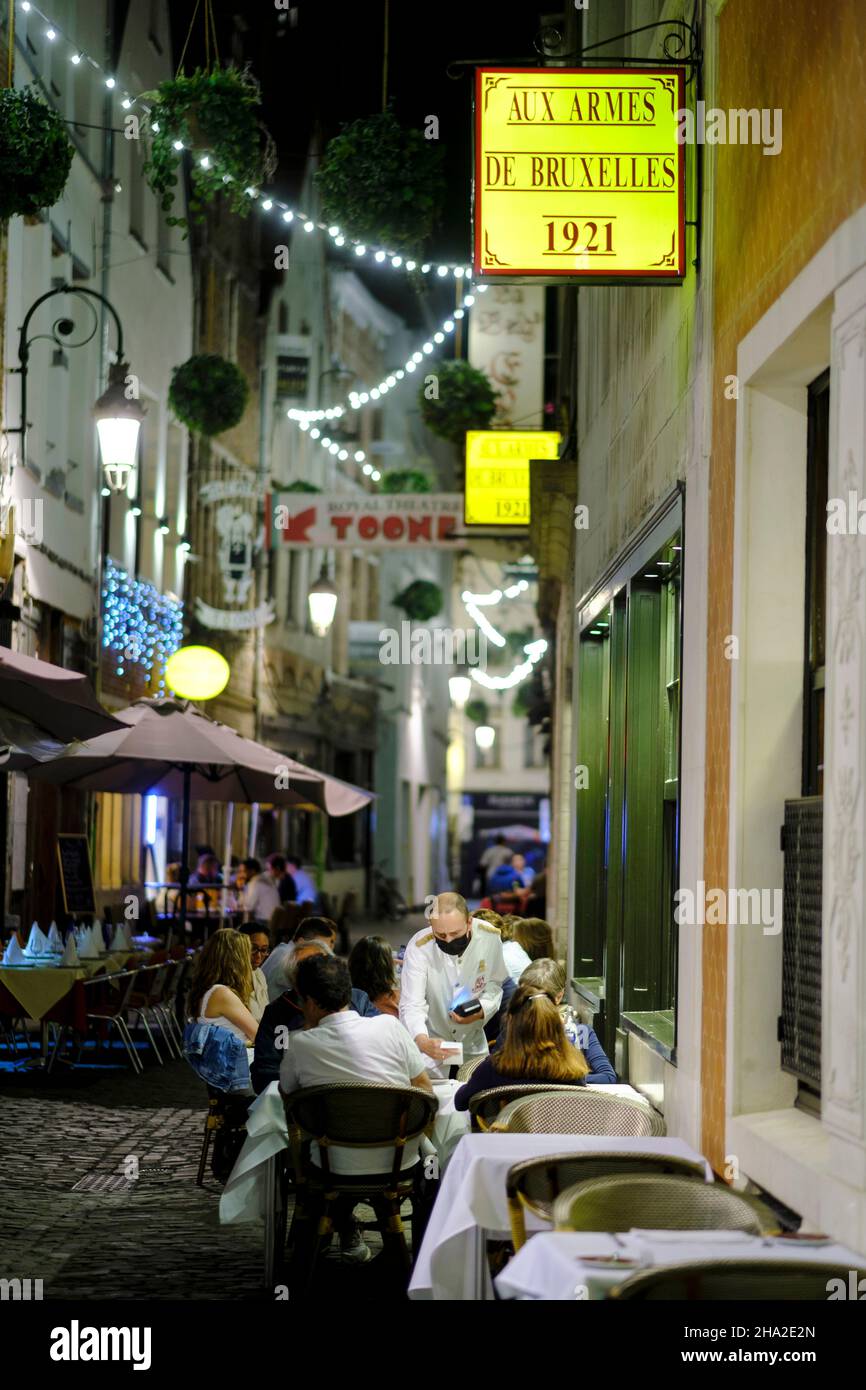 Belgium, Brussels: “petite rue des Bouchers” street in the historic center, in the district of “Ilot sacre”. Terrace of a restaurant in the evening Stock Photo
