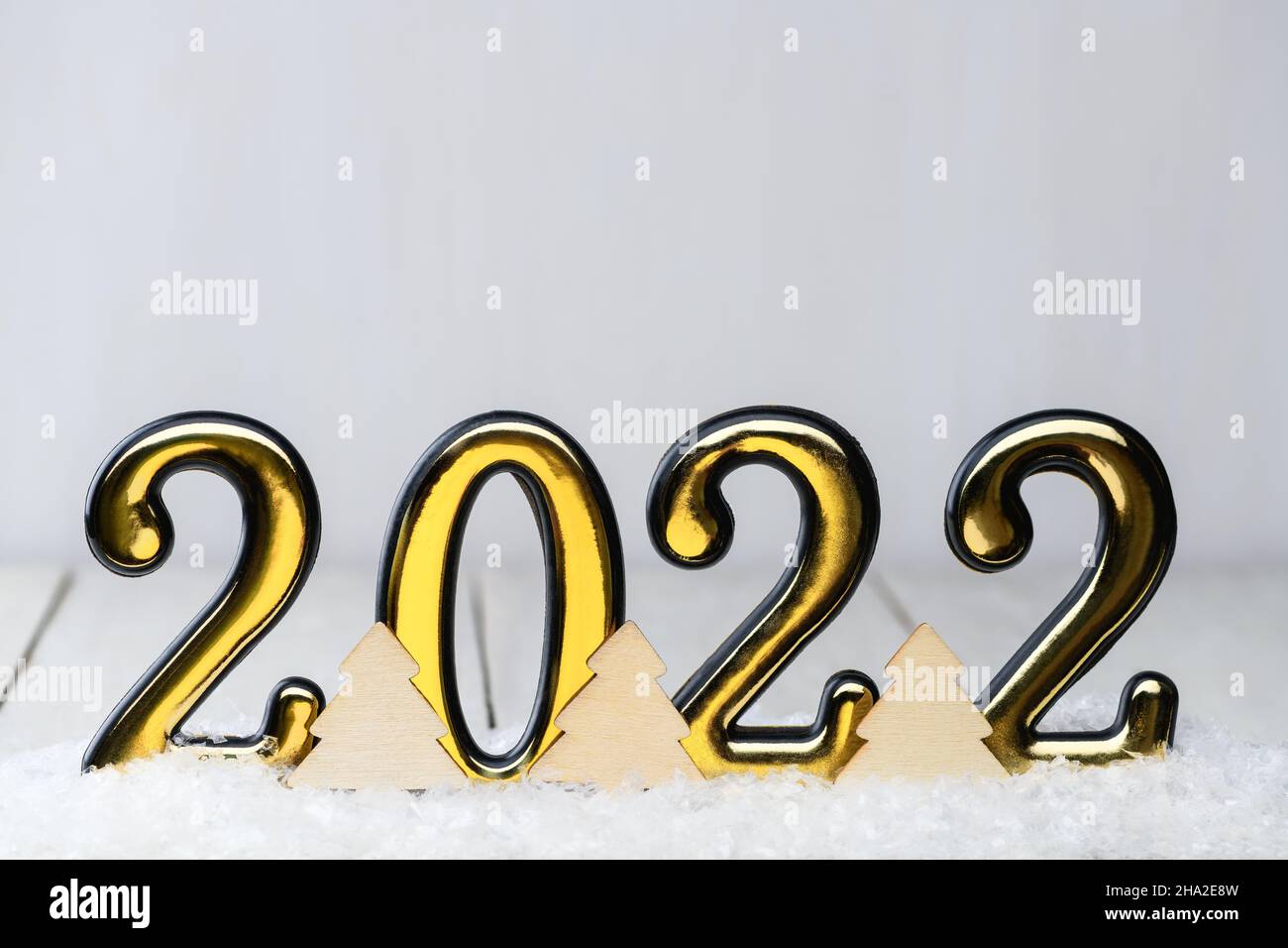 Gold numbers 2022 on white background with snow. New year backdrop with 2022 year Stock Photo