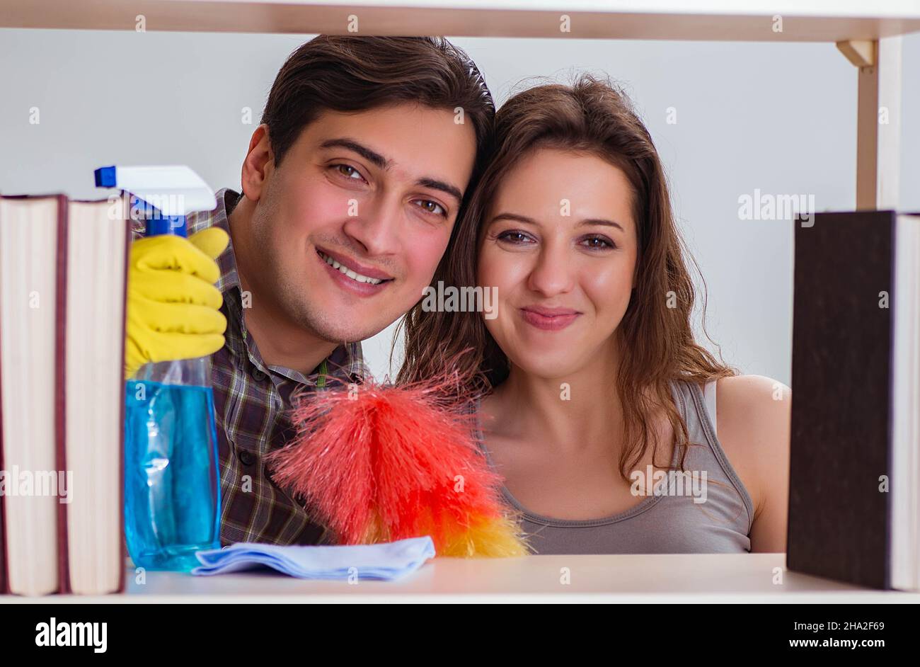 The wife and husband cleaning dust from bookshelf Stock Photo Alamy
