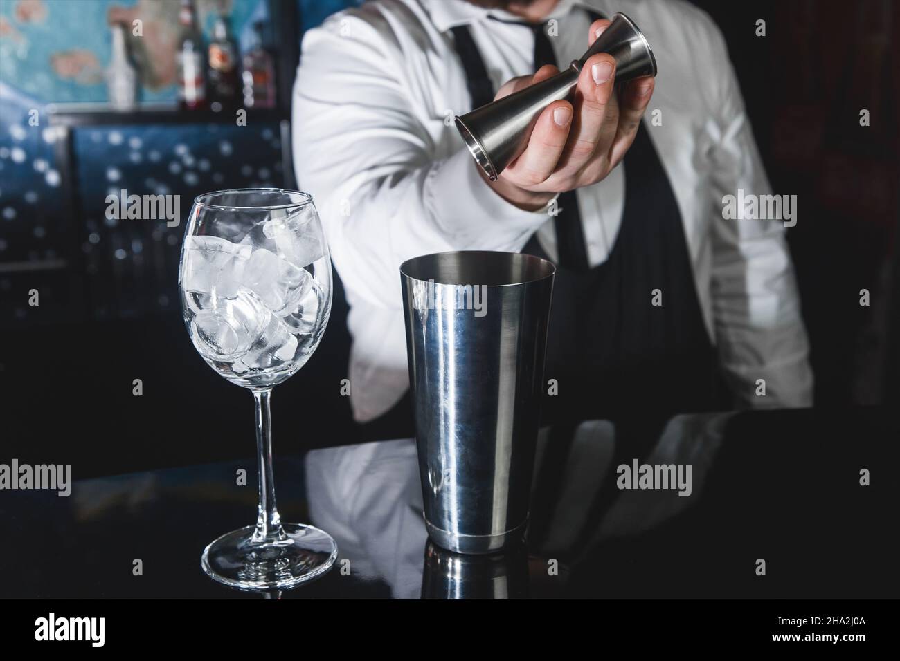 The hands of a professional bartender pour syrup into a measuring glass of  jigger in a metal tool for preparing and stirring alcoholic cocktails of sh  Stock Photo - Alamy