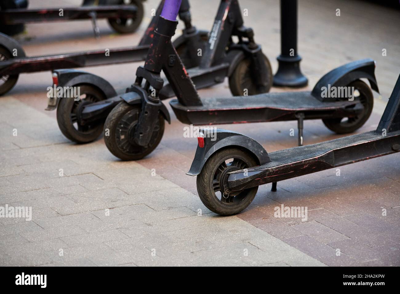 Motorized scooter parking for hourly rent on sidewalk street. Ride