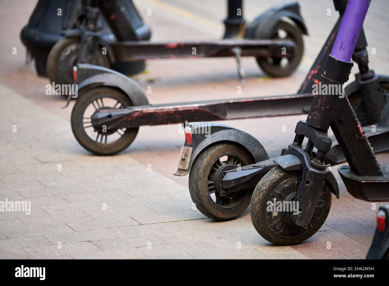 Motorized scooter parking for hourly rent on sidewalk street. Ride