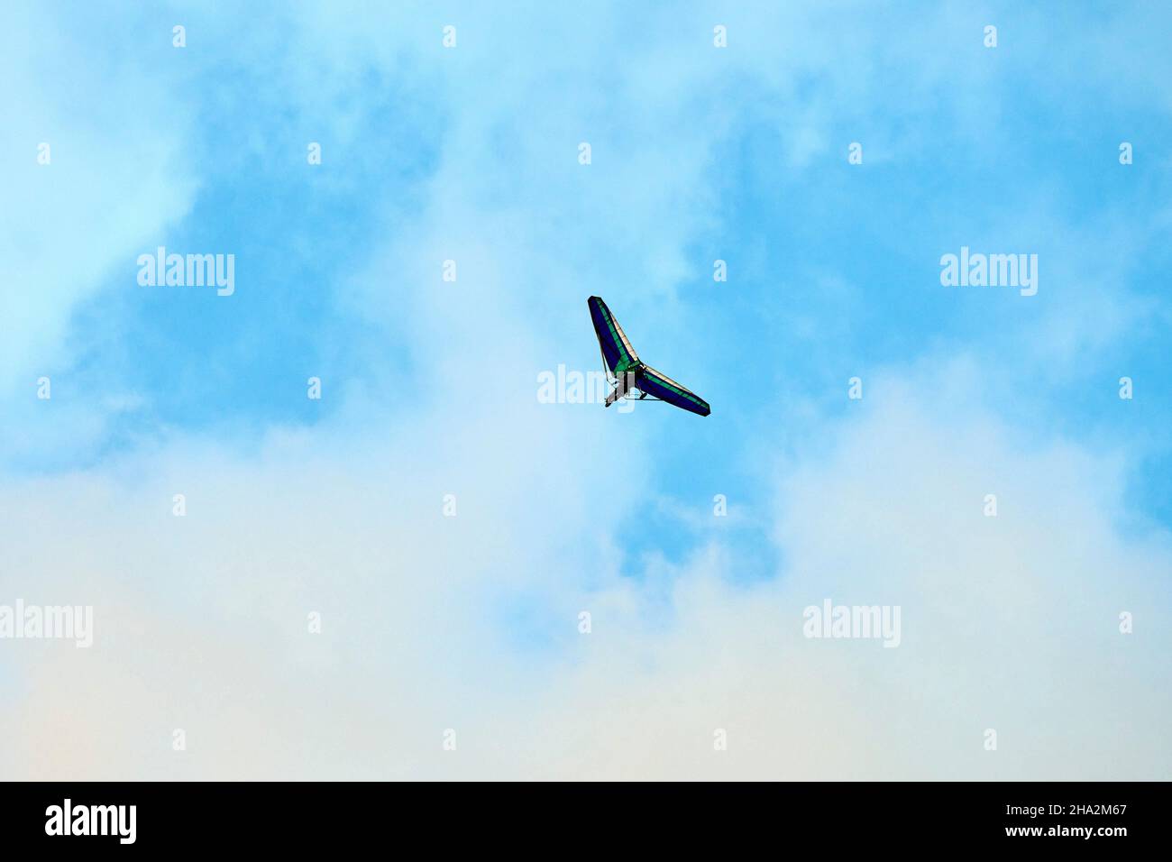 Powered hang glider flying in blue sky, motorized hang glider