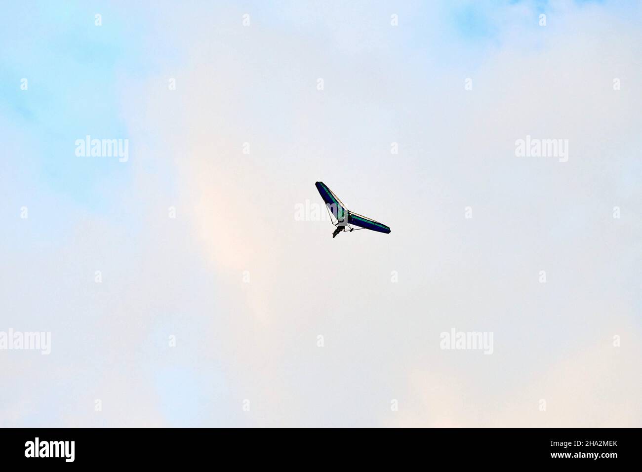 Powered hang glider flying in blue sky, motorized hang glider