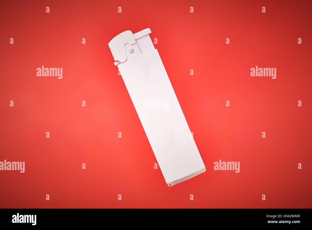 White pocket lighter on red background. Plastic lighter to ignite cigarettes, fireworks, candles