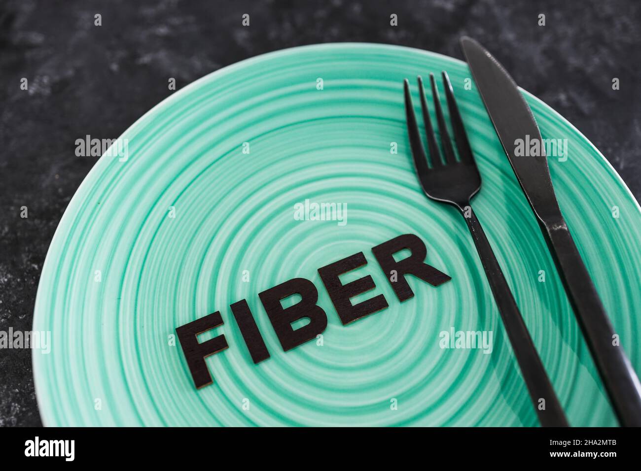 Fiber (US spelling) text on dining plate with fork and knife, concept