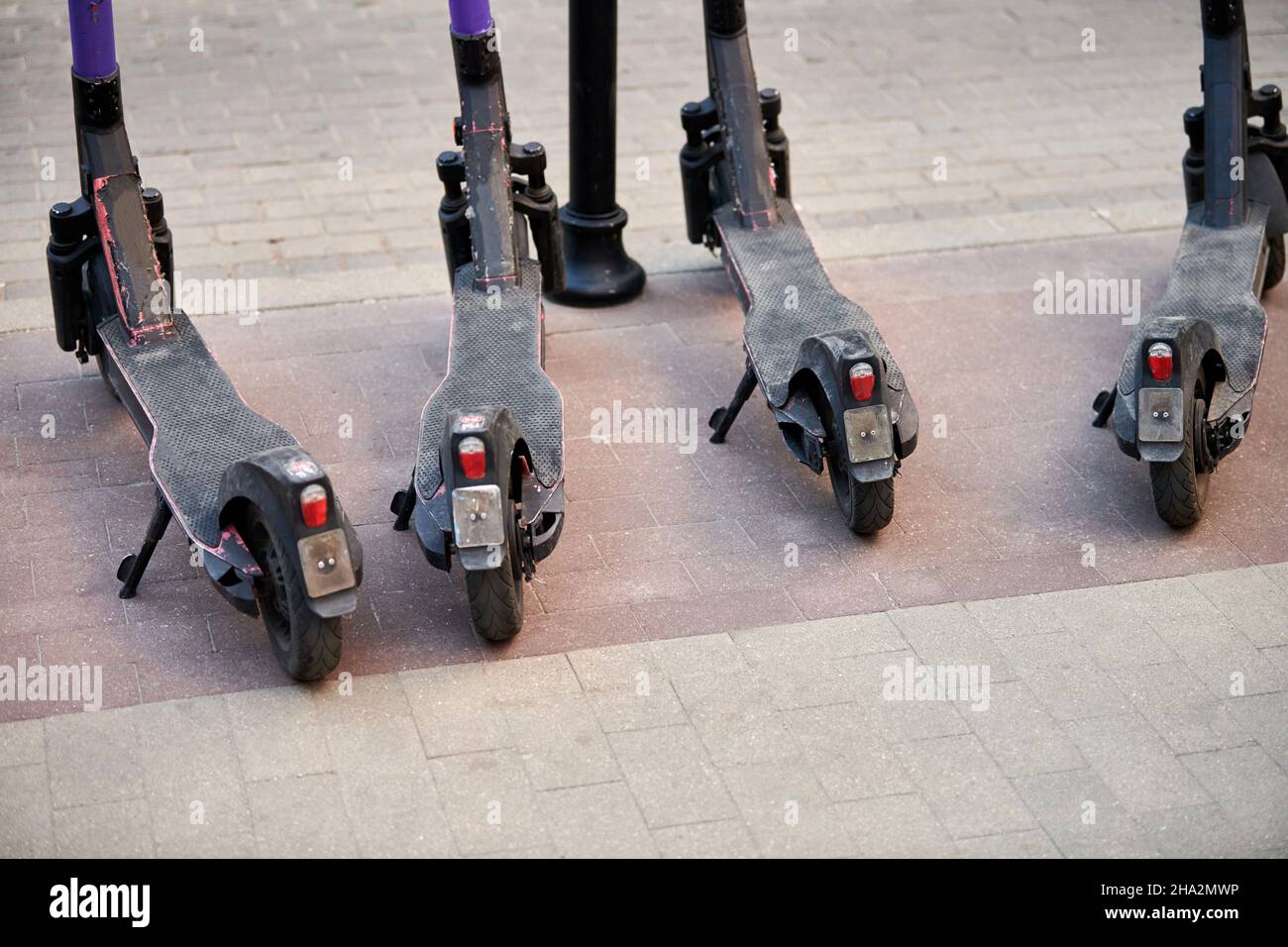 Motorized scooter parking for hourly rent on sidewalk street. Ride