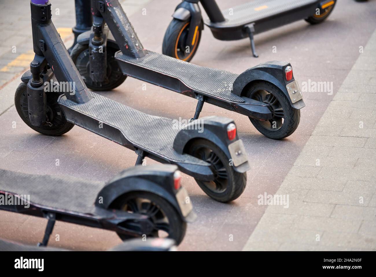 Motorized scooter parking for hourly rent on sidewalk street. Ride