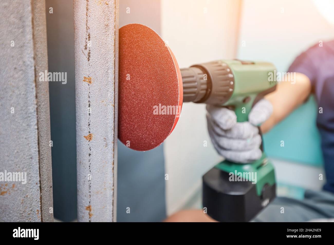 grinding wall or paint removal with disc sanding hand machine. Worker labor and equipment