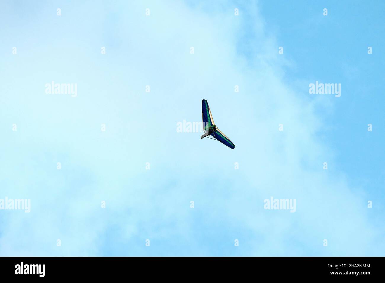 Powered hang glider flying in blue sky, motorized hang glider, ultralight trike overhead view