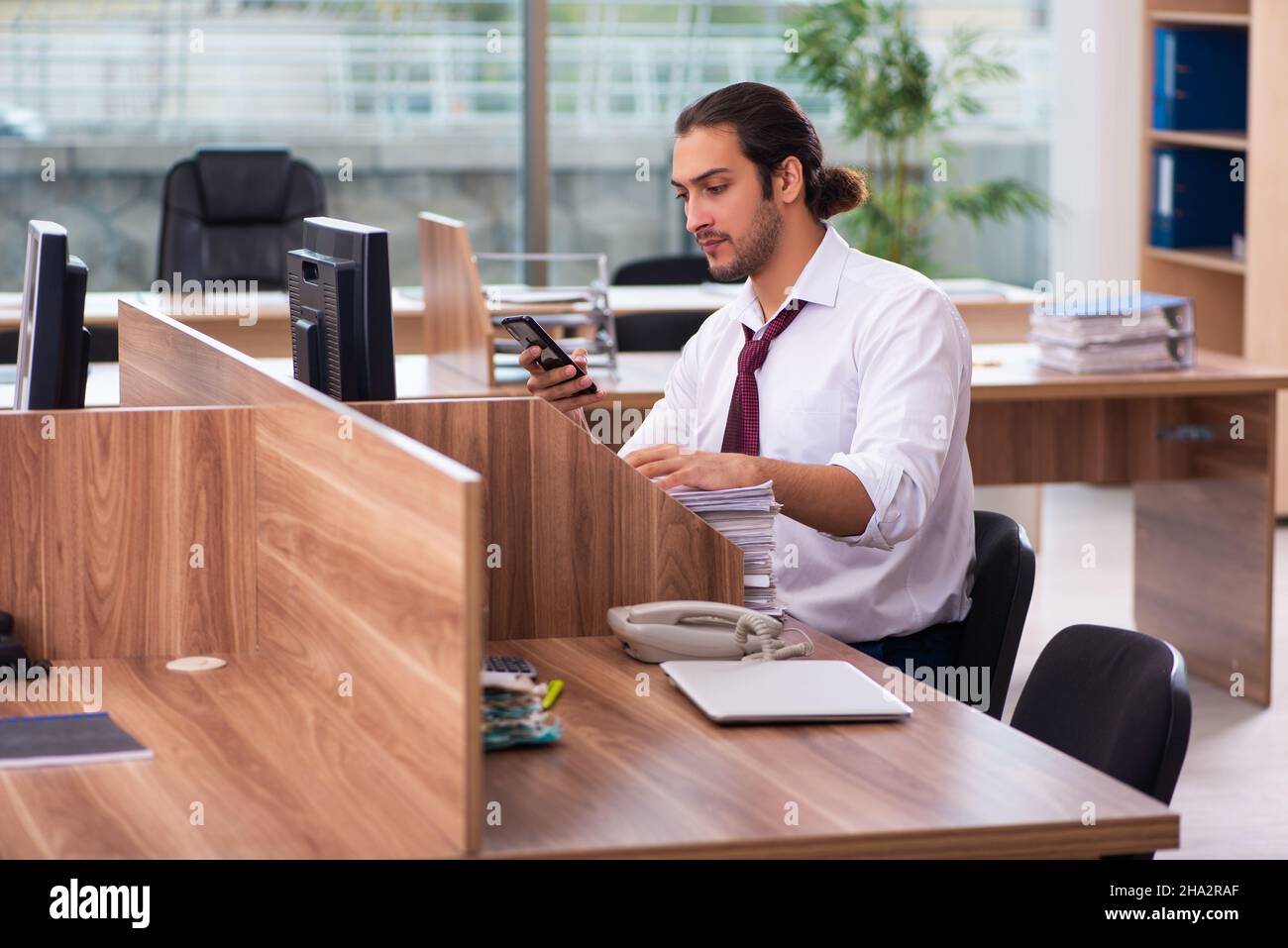 Young employee and too many work in the office Stock Photo - Alamy